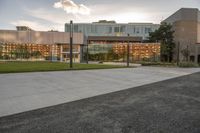 a large building that has a glass and stone facade in it's center of a grassy area near many trees