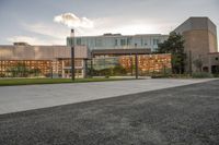 a large building that has a glass and stone facade in it's center of a grassy area near many trees