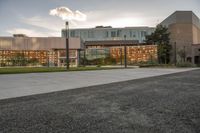 a large building that has a glass and stone facade in it's center of a grassy area near many trees