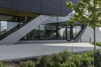 a building with a grass lawn in front of it and trees and bushes on the side of a walkway