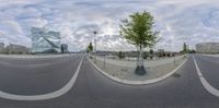 a wide view of a road in front of a modern building and trees outside the city