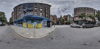 a circular lens shot shows a graffiti filled building next to a parking lot in an empty city