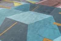 painted walkway on the side of a mountain with city in background next to trees and building