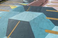 painted walkway on the side of a mountain with city in background next to trees and building