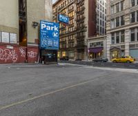 city street in new york with yellow taxi and sign with parking meter on wall near building