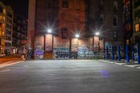 some street lights sitting by a building with graffiti on the walls of it, and blue poles in front