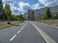 there is an empty street in front of a huge building under construction with trees around