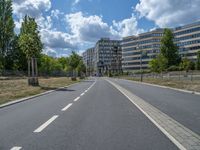 there is an empty street in front of a huge building under construction with trees around