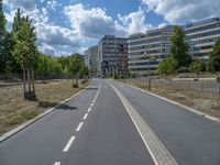 there is an empty street in front of a huge building under construction with trees around