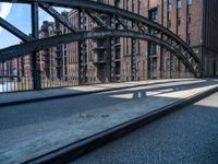 the train tracks have been set by the tall brick buildings and a sidewalk in front of them