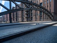 the train tracks have been set by the tall brick buildings and a sidewalk in front of them