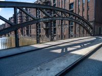 the train tracks have been set by the tall brick buildings and a sidewalk in front of them