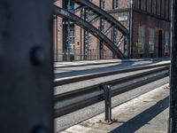 the gate to an open railroad station leads to a sidewalk, along with old buildings in the background