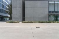 a parking spot is located in front of a gray building with lots of windows and greenery