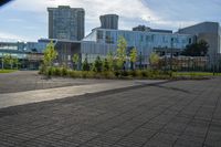 a person riding a skateboard on the sidewalk outside of a building and grass area