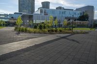 a person riding a skateboard on the sidewalk outside of a building and grass area