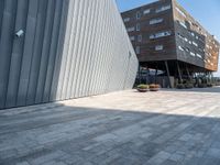 the sidewalk is cobblestone but it is a little nice looking outside of a large office building