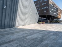 the sidewalk is cobblestone but it is a little nice looking outside of a large office building