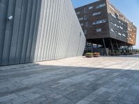 the sidewalk is cobblestone but it is a little nice looking outside of a large office building