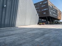 the sidewalk is cobblestone but it is a little nice looking outside of a large office building