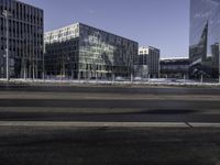 a city view with a bus crossing the road in front of buildings in winter with snow around