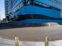 a pair of street poles in front of a building on a city street with cars passing through the road