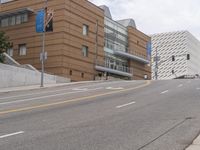 an empty street is shown in front of the museum's building and sidewalk with an empty bench