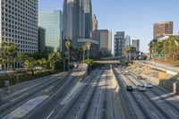 a city is on the side of a highway with many cars and skyscrapers in the background