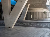 an open air parking garage with large beams and floor tiles in between the two arches