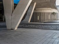 an open air parking garage with large beams and floor tiles in between the two arches