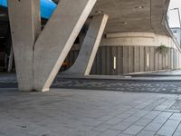 an open air parking garage with large beams and floor tiles in between the two arches