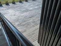 a picture looking down onto a building patio and a green park in the distance, including many plants