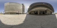 a large circular photograph of some sort of building outside a public space with cars parked near it