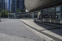 a person sitting at the bench in front of a mall that is empty of people