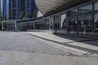 a person sitting at the bench in front of a mall that is empty of people