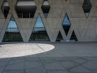 a concrete building with a lot of windows sitting on top of it with a circular pattern on the side