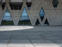 a concrete building with a lot of windows sitting on top of it with a circular pattern on the side