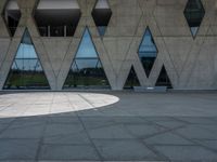 a concrete building with a lot of windows sitting on top of it with a circular pattern on the side