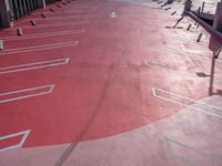 a parking lot with red and white lines on the ground and signs indicating that each area is a parking space