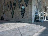 a view from the outside of an abstract, concrete building with lots of windows and glass on both sides