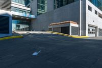 an empty paved walkway by a building on a sunny day with no people walking around