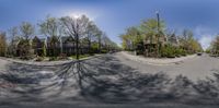 a fish eye view of an empty city street with some tall houses in the background