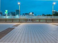 people standing on a subway platform with many buildings in the background at night light in tokyo