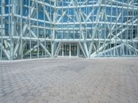 a view from the outside looking towards an office building and its outside glass walls are reflecting the sun