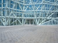 a view from the outside looking towards an office building and its outside glass walls are reflecting the sun
