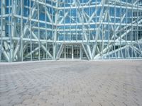 a view from the outside looking towards an office building and its outside glass walls are reflecting the sun