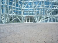 a view from the outside looking towards an office building and its outside glass walls are reflecting the sun