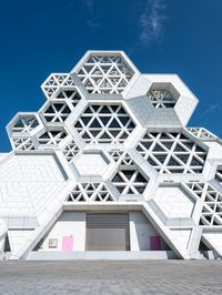 a building made out of concrete blocks with pink doors and windows at the entrance of it