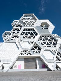 a building made out of concrete blocks with pink doors and windows at the entrance of it