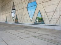 the entrance to an empty building has several large windows reflecting it's surroundings across the street